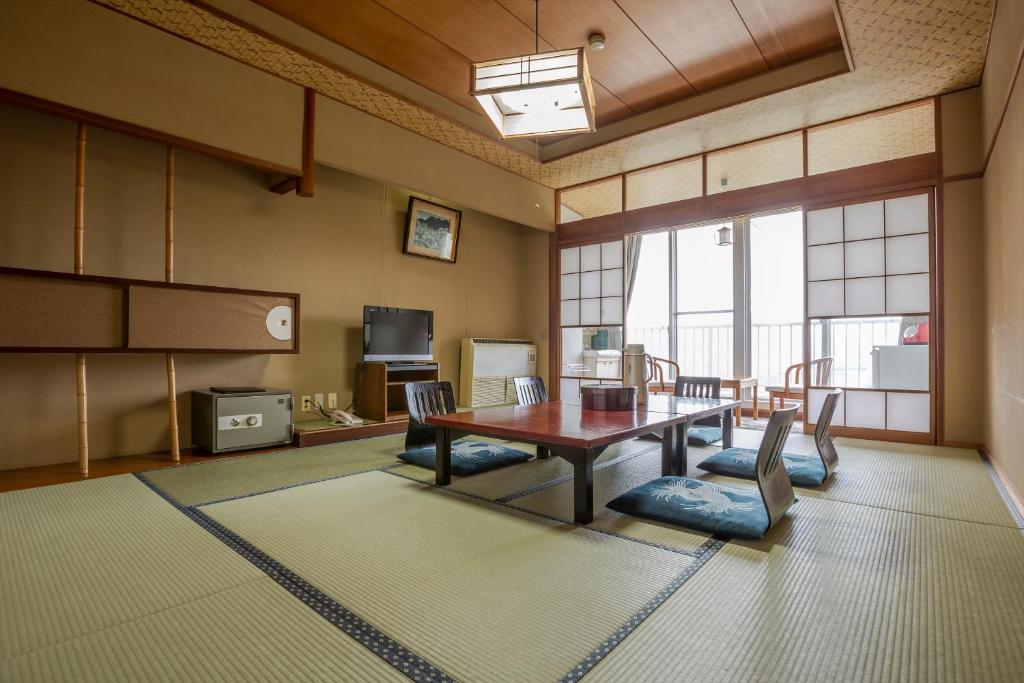 une salle à manger avec une table et des chaises en bois dans l'établissement Tsuruga Tunnel Onsen Kitaguni Grand Hotel, à Tsuruga