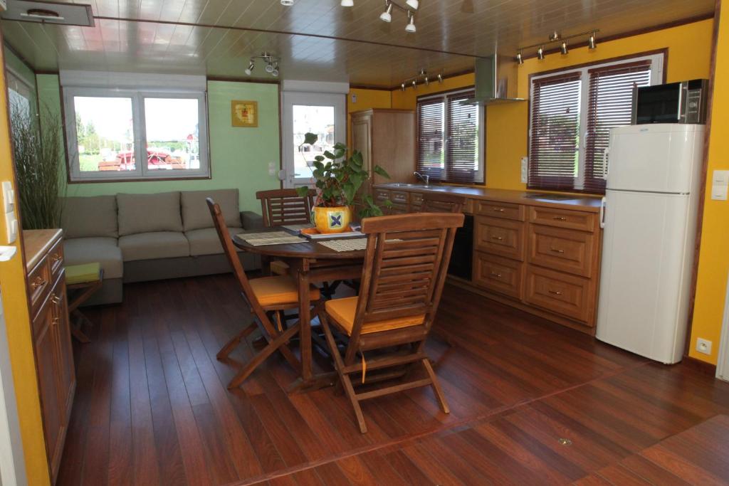 une cuisine et une salle à manger avec une table et un réfrigérateur dans l'établissement Gîte Fluvial de La Baie de Somme Le Lihoury, à Saint-Valery-sur-Somme 22 autres photos