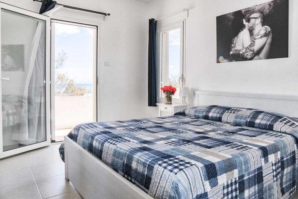 une chambre avec un lit et une grande fenêtre dans l'établissement Centro Vacanze Lido Smeraldo, à Frigole