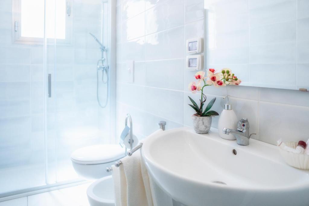 une salle de bain blanche avec un lavabo et des toilettes dans l'établissement Centro Vacanze Lido Smeraldo, à Frigole 36 autres photos