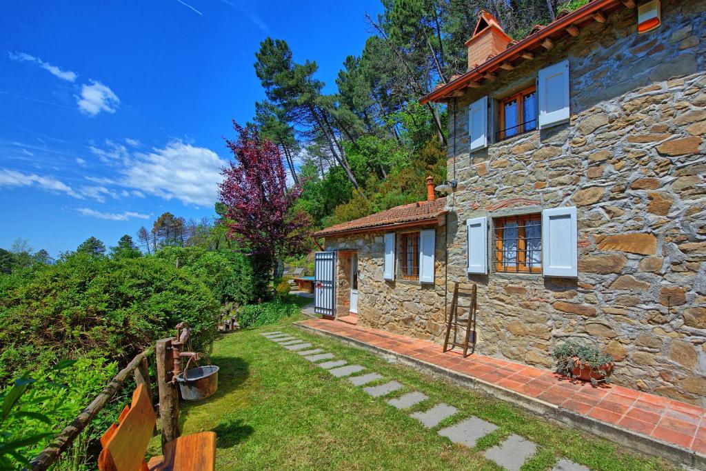 une maison en pierre avec un jardin en face dans l'établissement Casale di Cozzile by PosarelliVillas, à Massa e Cozzile