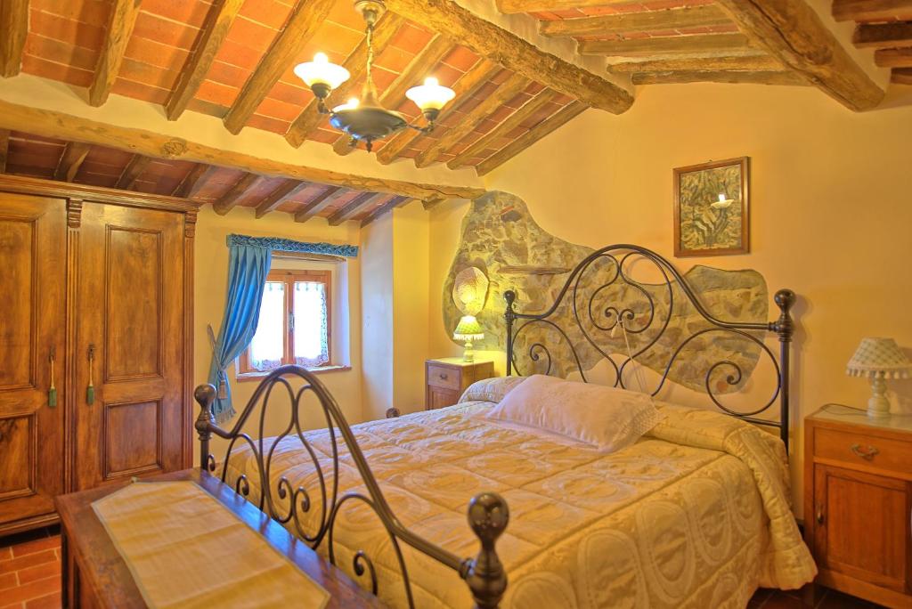 une chambre avec un lit et un plafond en bois dans l'établissement Casale di Cozzile by PosarelliVillas, à Massa e Cozzile