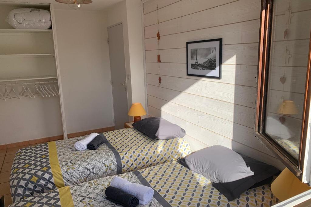 Cette chambre comprend 2 lits et un miroir. dans l'établissement SERRE CHEVALIER 1200, à Briançon