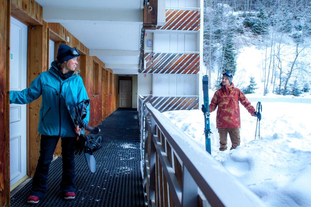 Deux hommes sont debout dans la neige sur un bâtiment dans l'établissement Résidence Capfun du Téléphérique, Morzine, à Morzine