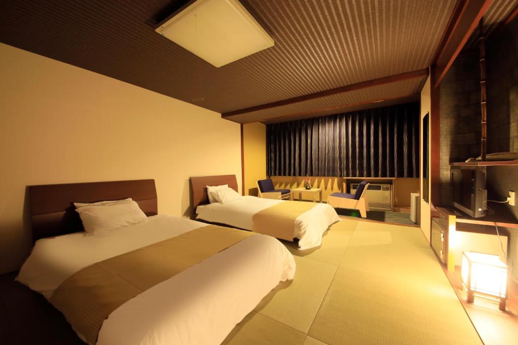 une chambre d'hôtel avec deux lits et une télévision dans l'établissement Yutorelo Toyako, à Lac Tōya 37 autres photos