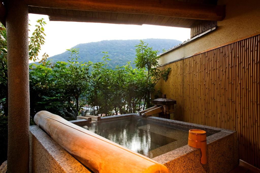 d'une baignoire avec vue sur la montagne. dans l'établissement Yumoto Konpira Onsen Hananoyu Kobaitei, à Kotohira
