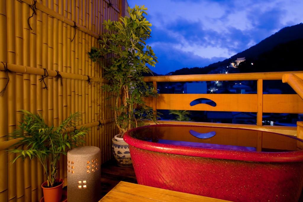 une baignoire rouge assise sur un balcon orné de plantes dans l'établissement Kotohira Grand Hotel Sakuranosho, à Kotohira 37 autres photos
