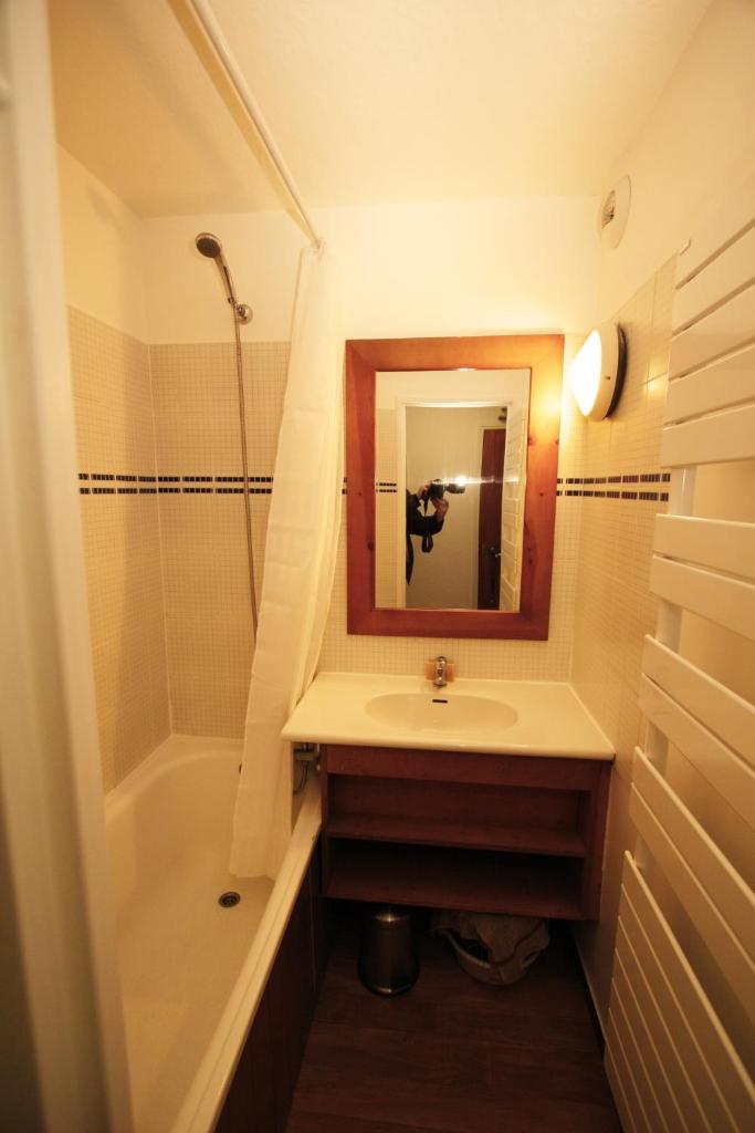 une salle de bain avec un lavabo, une douche et un miroir dans l'établissement Le Rond Point des Pistes, à Tignes