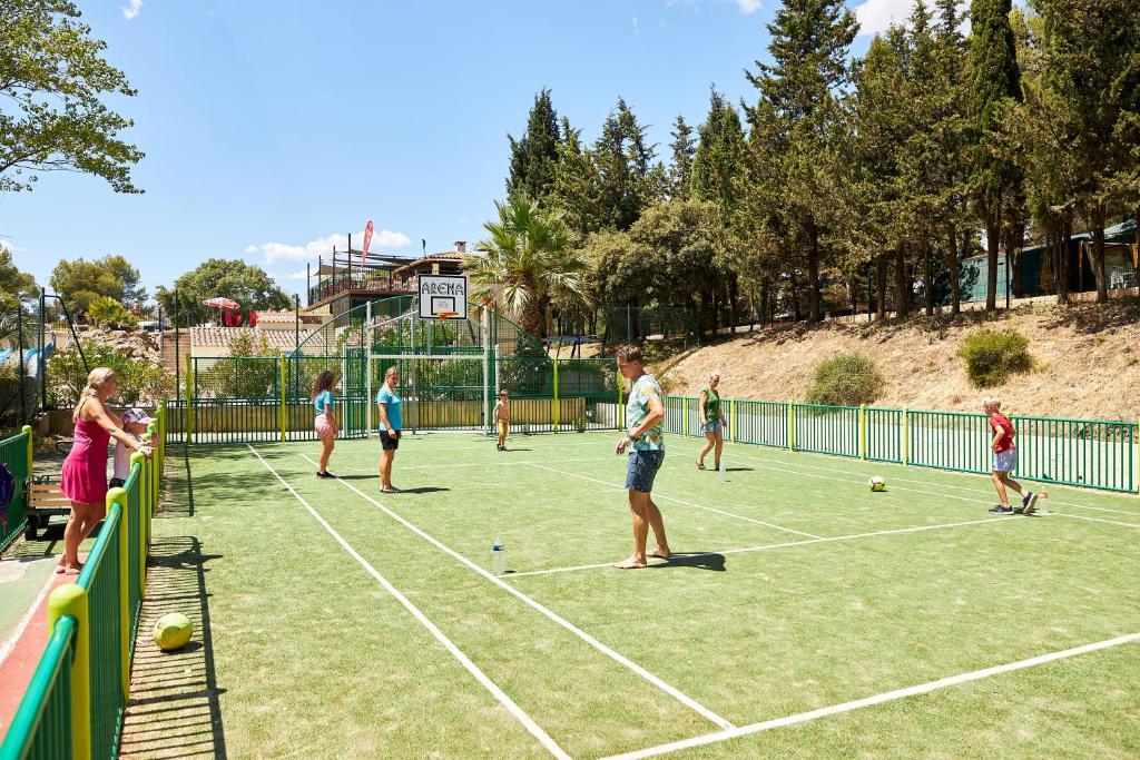 un groupe de personnes jouant au tennis sur un court de tennis dans l'établissement Camping RCN Domaine de la Noguière, au Muy