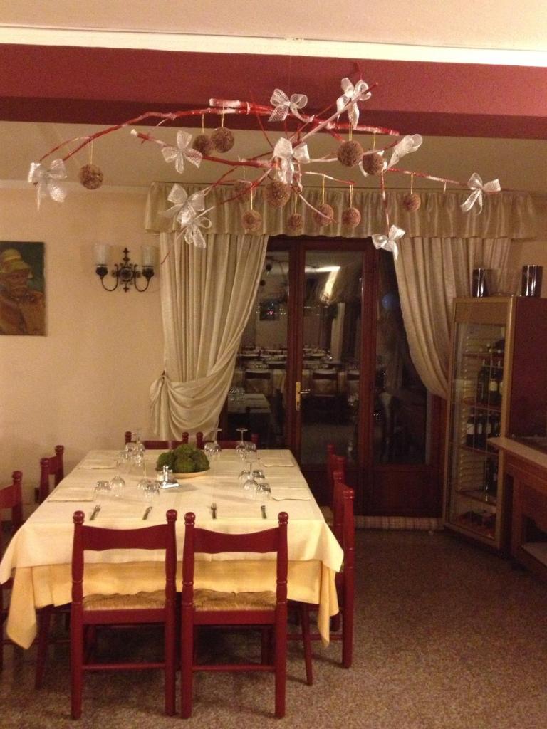 - une table à manger avec une nappe et des chaises blanches dans l'établissement Albergo Ristorante Punta Dell'Est, à Clusane