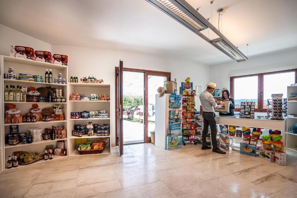 un homme debout à un comptoir dans un magasin dans l'établissement Grande Baia Resort & Spa, à San Teodoro