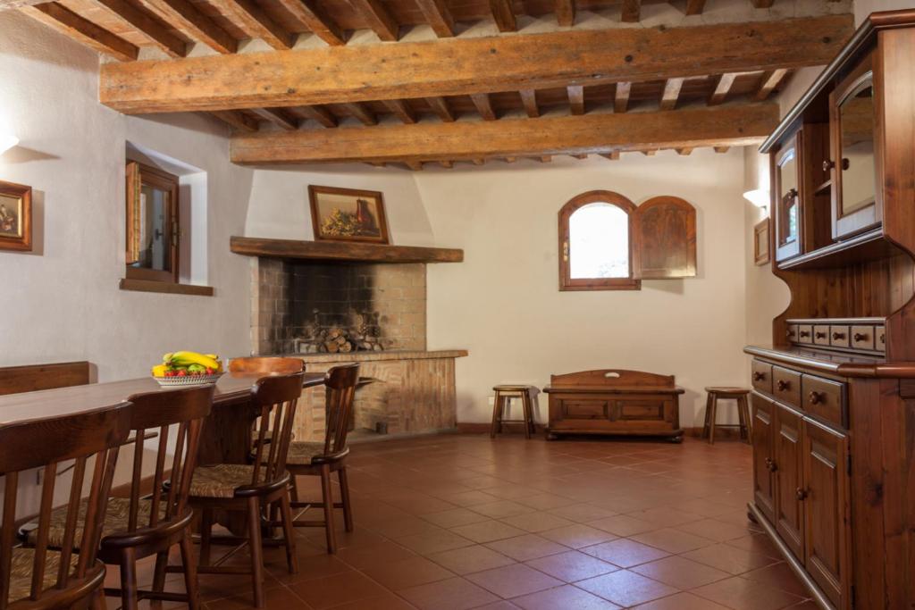une cuisine avec une cheminée, une table et des chaises dans l'établissement Residence La Canova II, à Marina di Grosseto