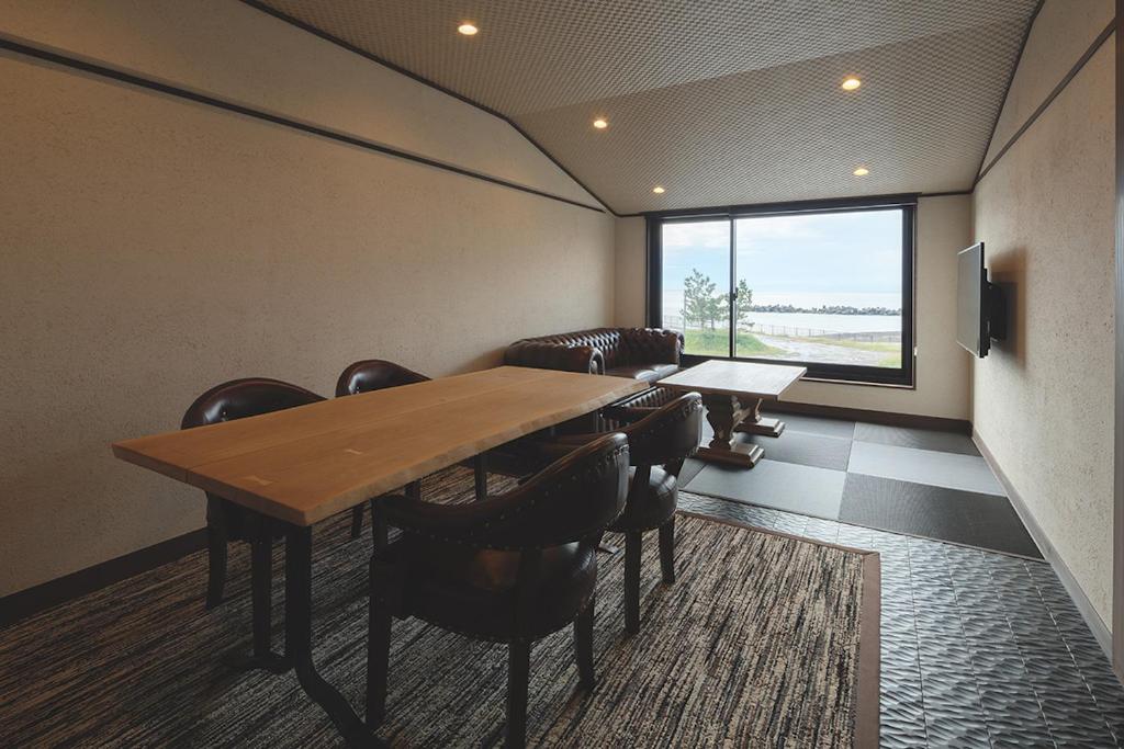 d'une salle de conférence avec une table, des chaises et une fenêtre. dans l'établissement Arujisu, à Izu
