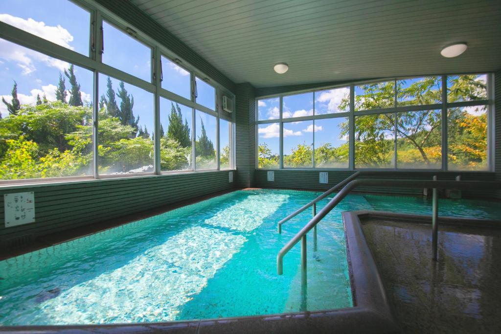 - une grande piscine intérieure avec fenêtres dans une maison dans l'établissement Omuta Heights, à Ōmuta