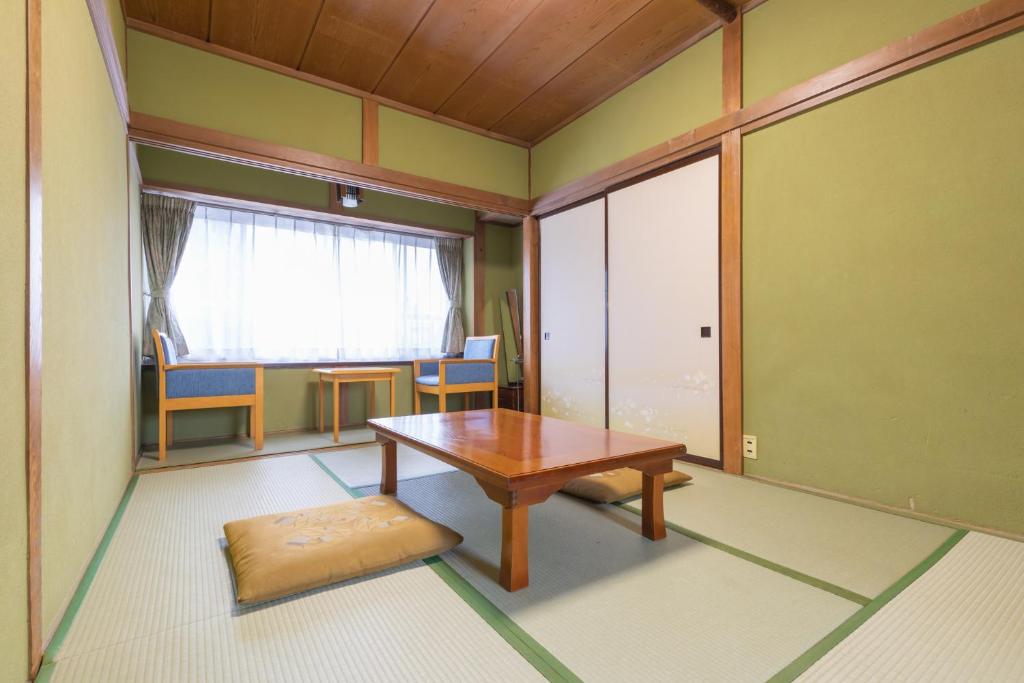 Cette chambre dispose d'une table en bois et d'une fenêtre. dans l'établissement Hanamizuki, à Yamanakako