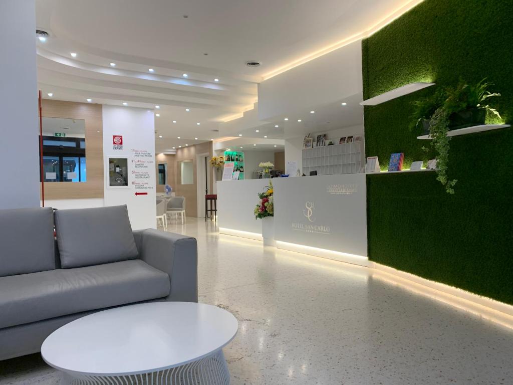 un salon avec un canapé et une table dans l'établissement Hotel San Carlo, à Lignano Sabbiadoro
