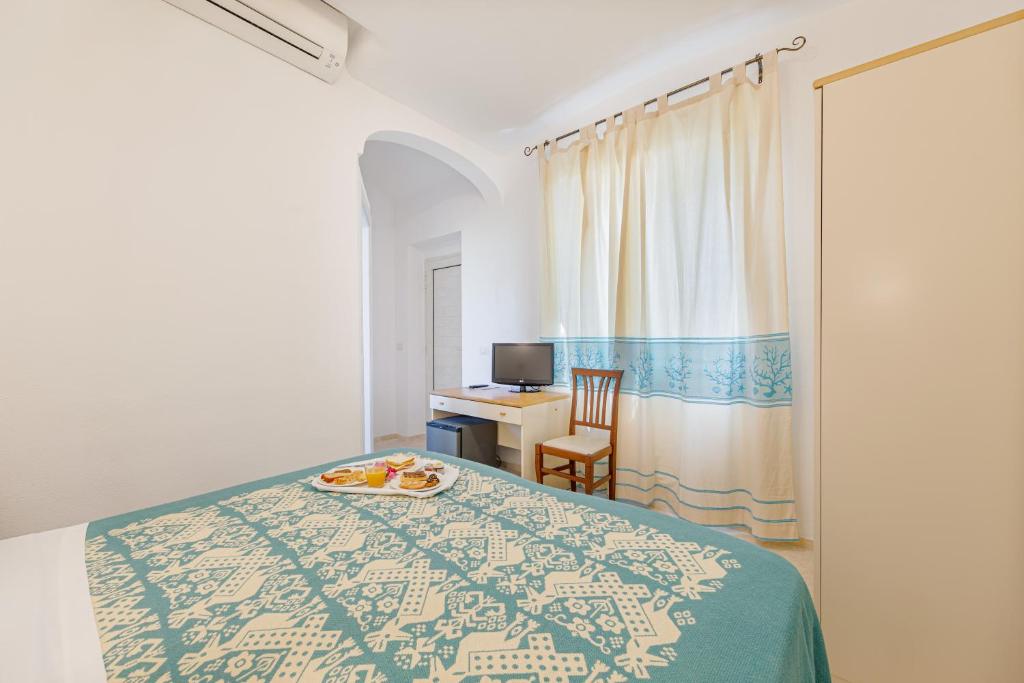 - une chambre avec un lit et une assiette de nourriture dans l'établissement Hotel Le Mimose, à San Teodoro