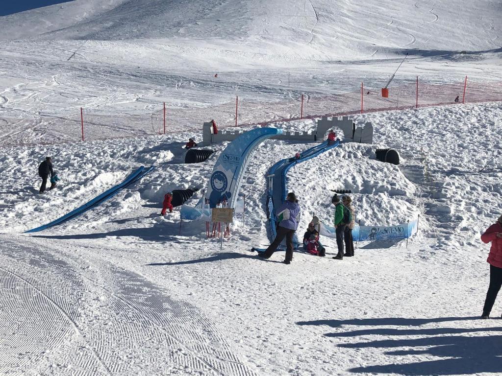 Un groupe de personnes debout autour d'une lame dans la neige dans l'établissement Studio Chalet club - pied des pistes, à Valfréjus