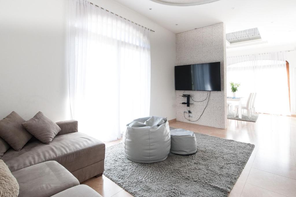 un salon blanc avec un canapé et une télévision dans l'établissement Villa Luxury House & Spa, à Riva del Garda