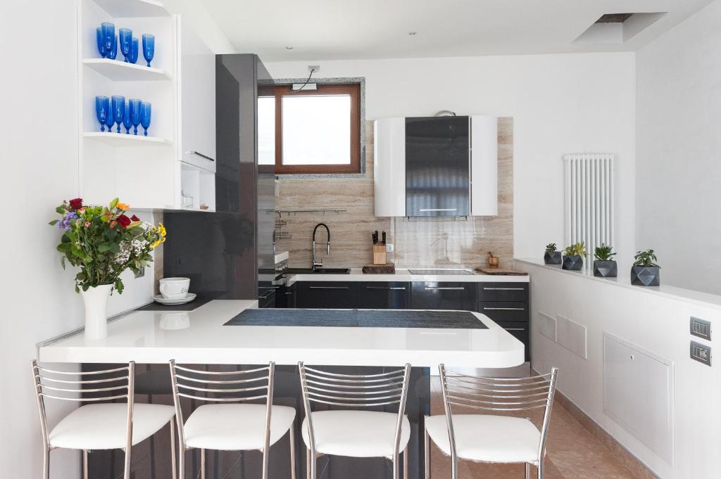 une cuisine avec un grand îlot blanc avec des chaises dans l'établissement Villa Luxury House & Spa, à Riva del Garda