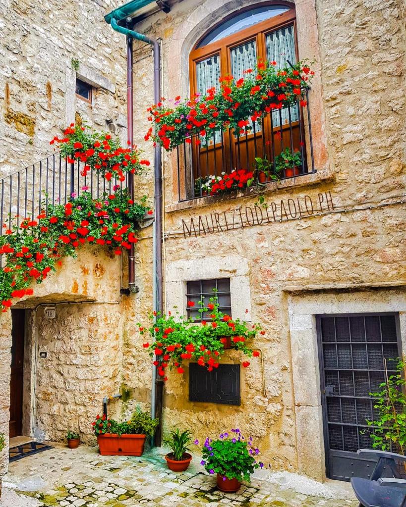 un bâtiment avec des boîtes de fleurs sur son côté dans l'établissement HOTEL HOLIDAYS a Barrea - Natura, Relax e Benessere nel Parco d'Abruzzo, à Barrea