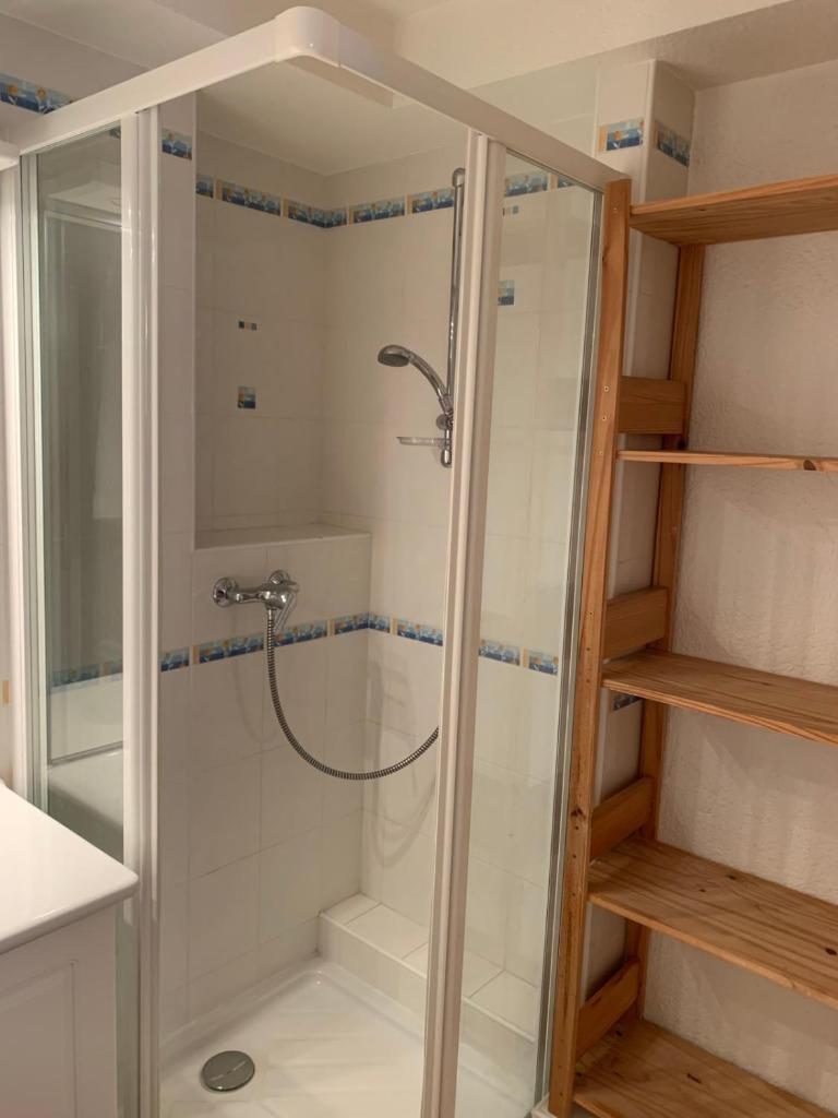 une douche avec une porte vitrée dans une salle de bain dans l'établissement SERRE CHEVALIER 1200, à Briançon