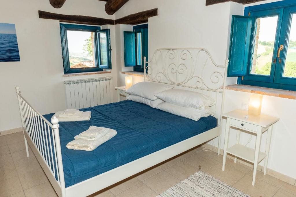 - une chambre avec un lit doté de draps bleus et d'oreillers blancs dans l'établissement Casa Pace e Gioia, à Tolentino