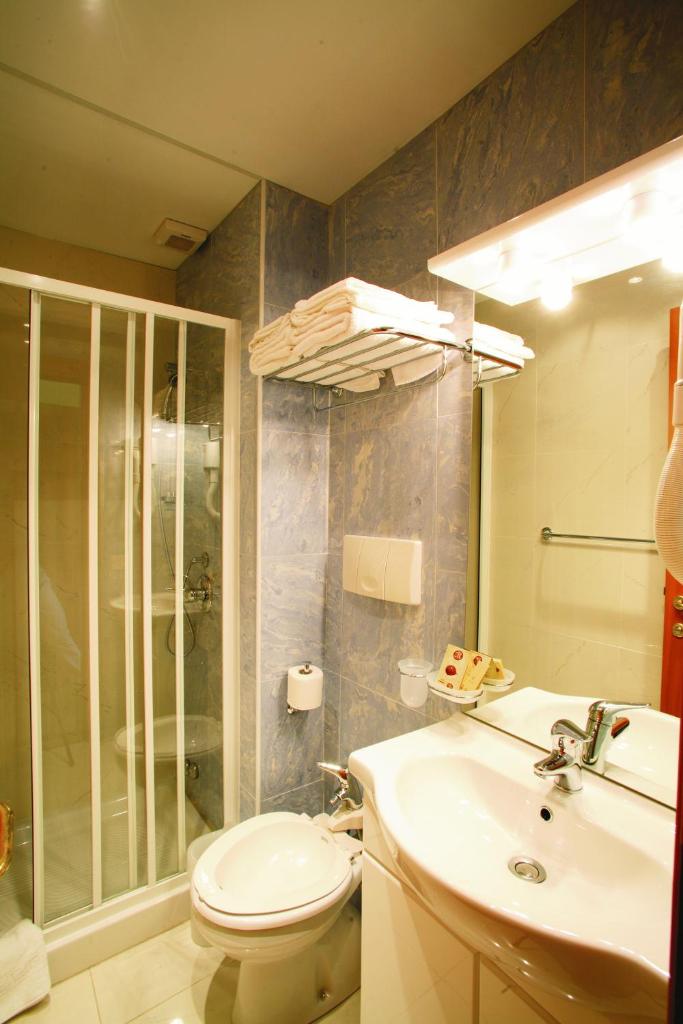 une salle de bain avec toilettes, lavabo et douche dans l'établissement Eurotel, à Grottammare