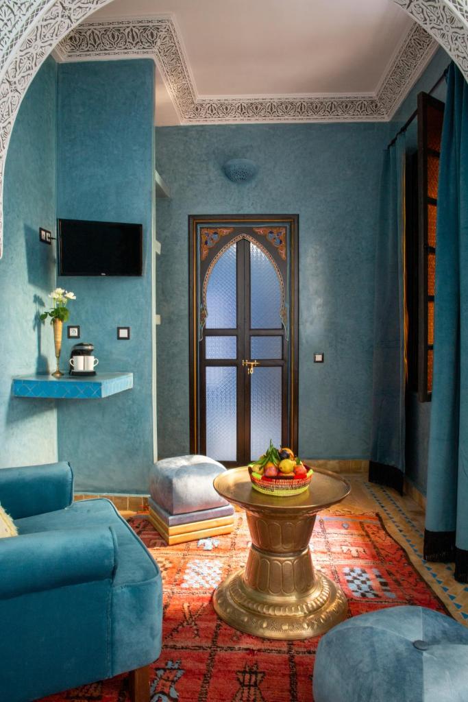- un salon bleu avec une table et un canapé dans l'établissement Riad Touda, à Marrakech