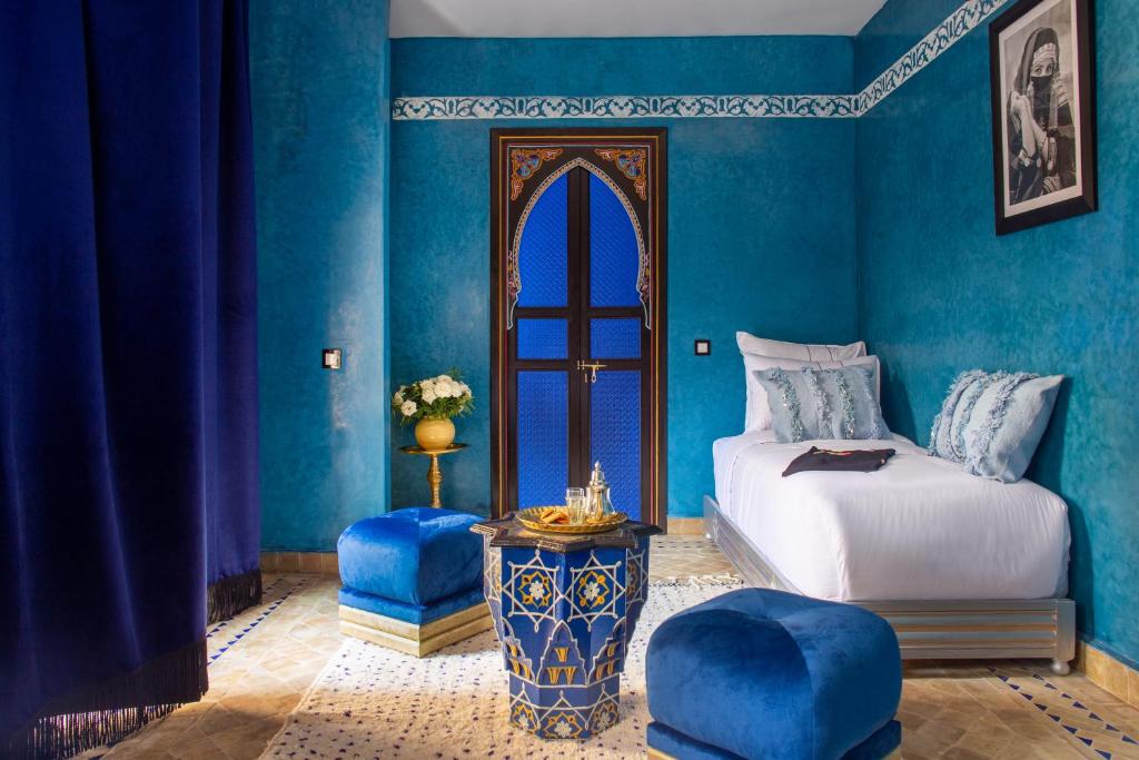 - une chambre avec des murs bleus, un lit et une table dans l'établissement Riad Touda, à Marrakech 37 autres photos