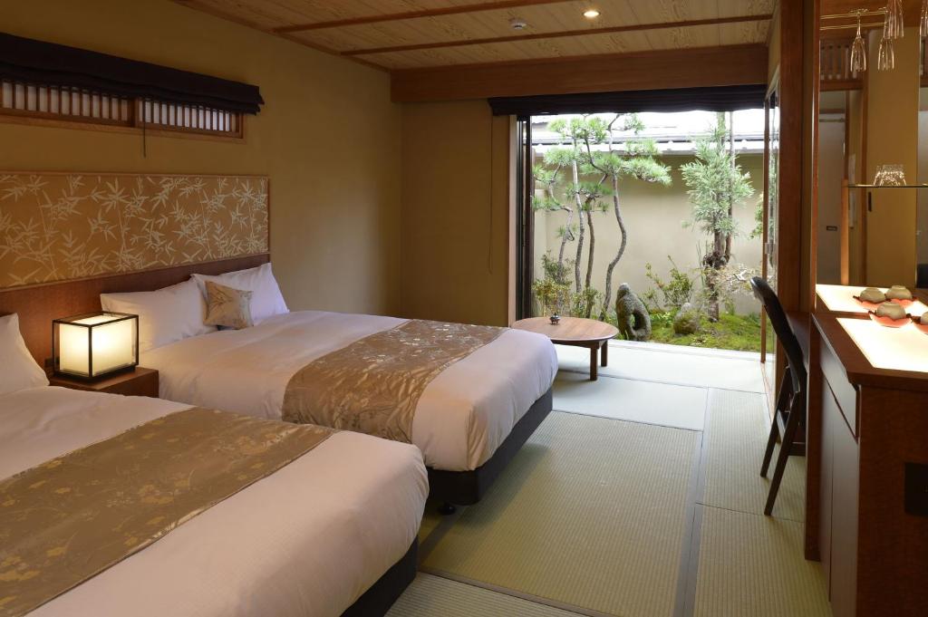 une chambre d'hôtel avec deux lits et une fenêtre dans l'établissement Gion Oyado Kikutani, à Kyoto
