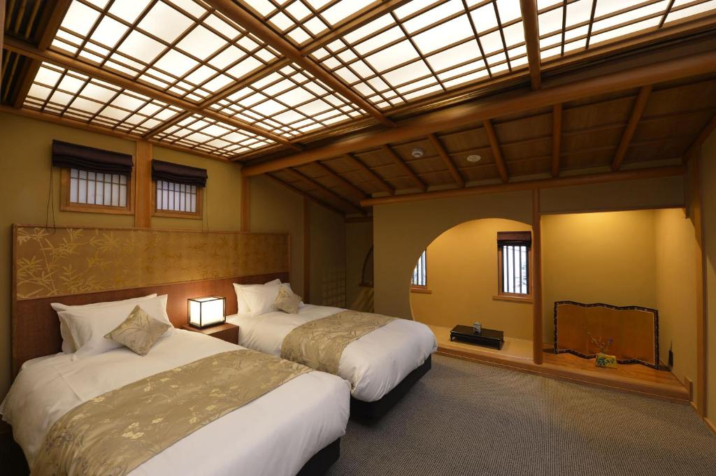 une chambre avec deux lits et une lucarne dans l'établissement Gion Oyado Kikutani, à Kyoto