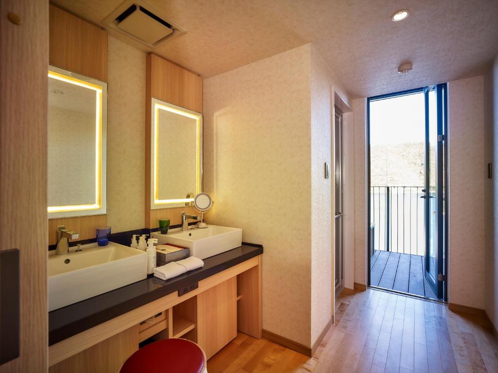 une salle de bain avec un lavabo et un miroir dans l'établissement Kumano-bettei Nakanoshima, à Katsuura