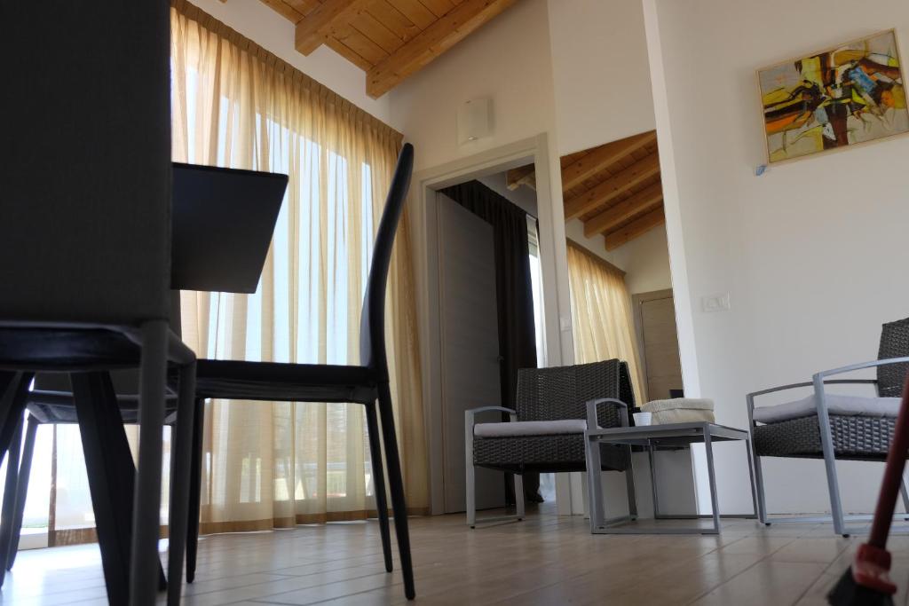 une chambre avec des chaises, une télévision et une table dans l'établissement Campeggio Villaggio San Giorgio Vacanze, à Manerba del Garda