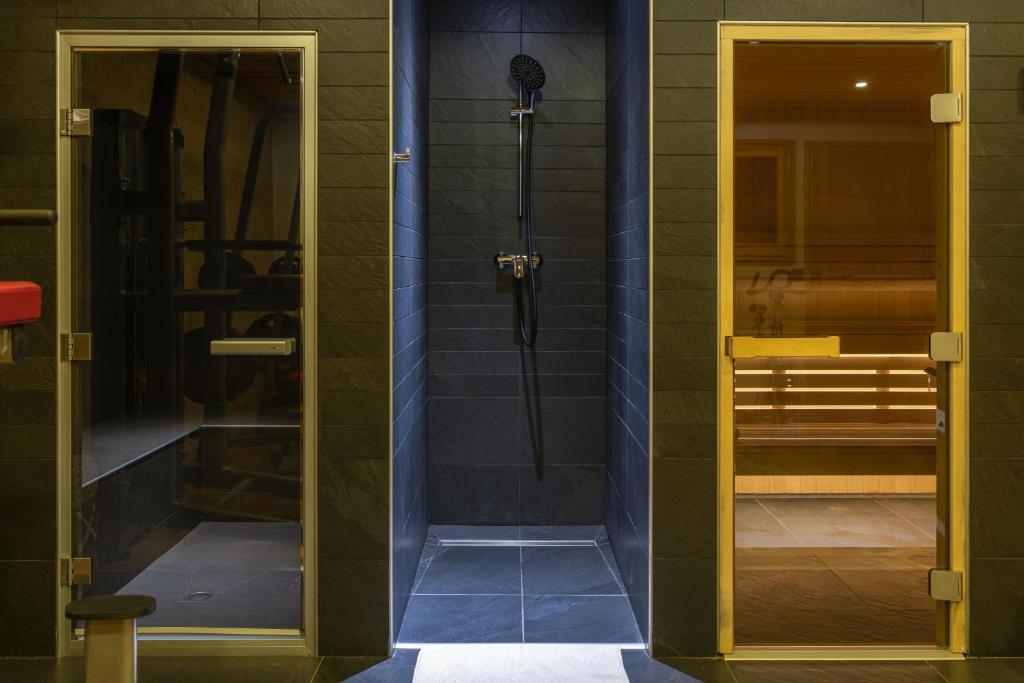 une salle de bain avec une douche avec une porte vitrée dans l'établissement Chalet Lodge Oberig Exclusive, à Villard-Reculas 37 autres photos
