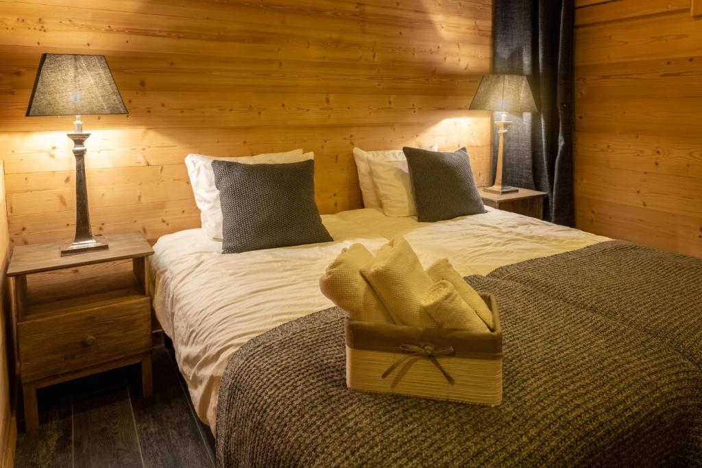 - une chambre avec deux lits, deux lampes et un lit avec une boîte dans l'établissement Chalet Lodge Oberig Exclusive, à Villard-Reculas
