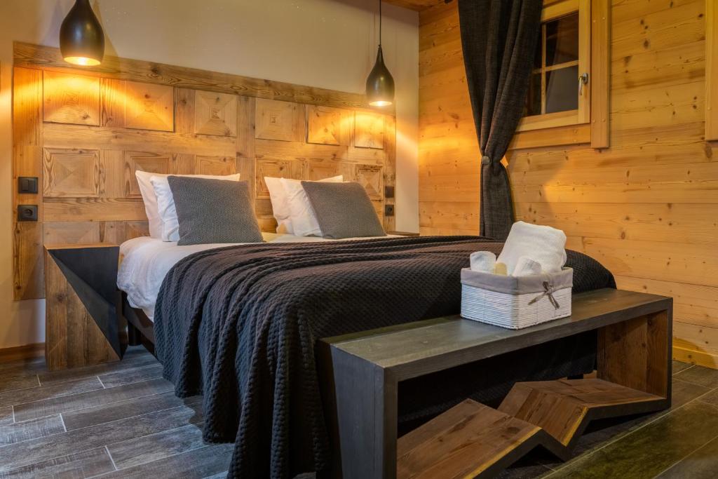 - une chambre avec un lit et un mur en bois dans l'établissement Chalet Lodge Oberig Exclusive, à Villard-Reculas