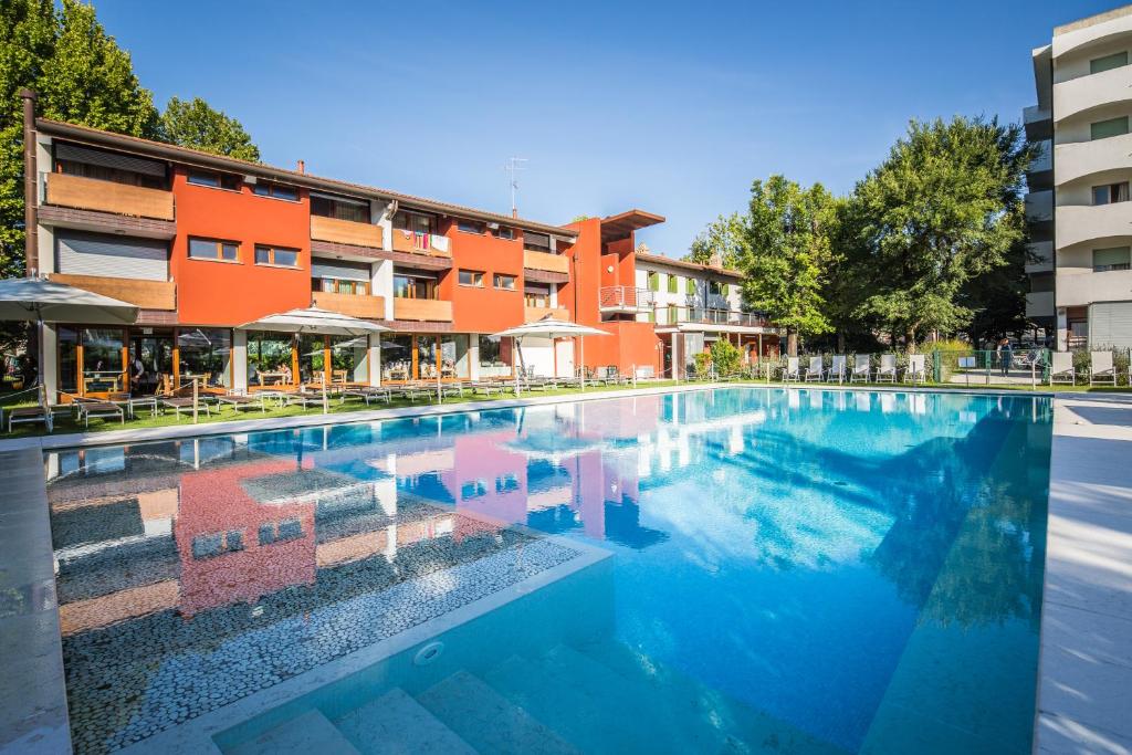 une piscine devant un bâtiment dans l'établissement Hotel La Pergola, à Lignano Sabbiadoro