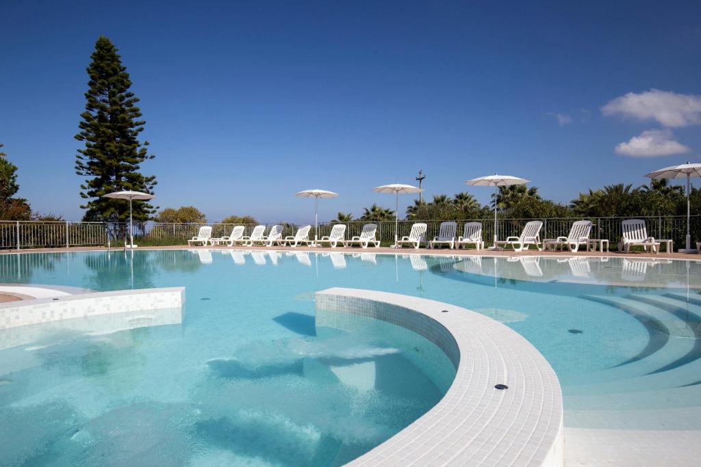 une grande piscine avec des chaises et de l'eau bleue dans l'établissement Happy Days, à Capo Vaticano 32 autres photos