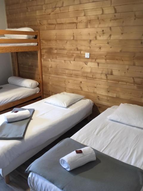 - 3 lits dans une chambre dotée de murs en bois dans l'établissement Les Carlines, à Vars
