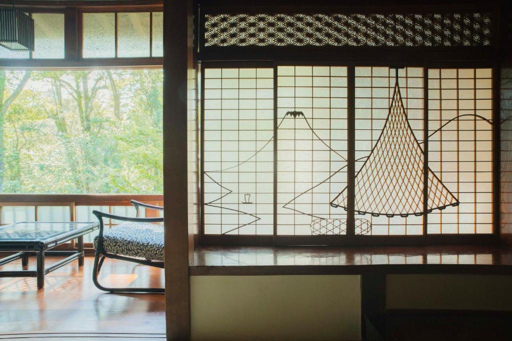 Cette chambre dispose d'une fenêtre avec une chaise et une table. dans l'établissement Ochiairo, à Izu 161 autres photos