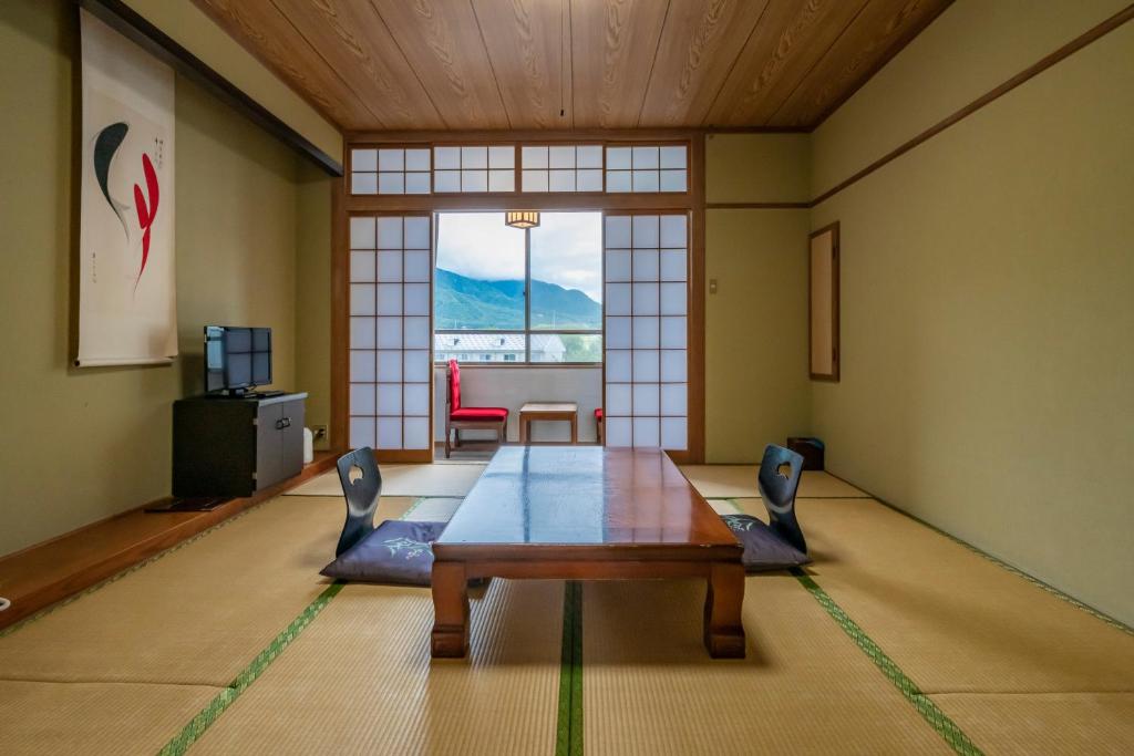 un salon avec une table et des chaises et une fenêtre dans l'établissement Kurobe View Hotel, à Omachi
