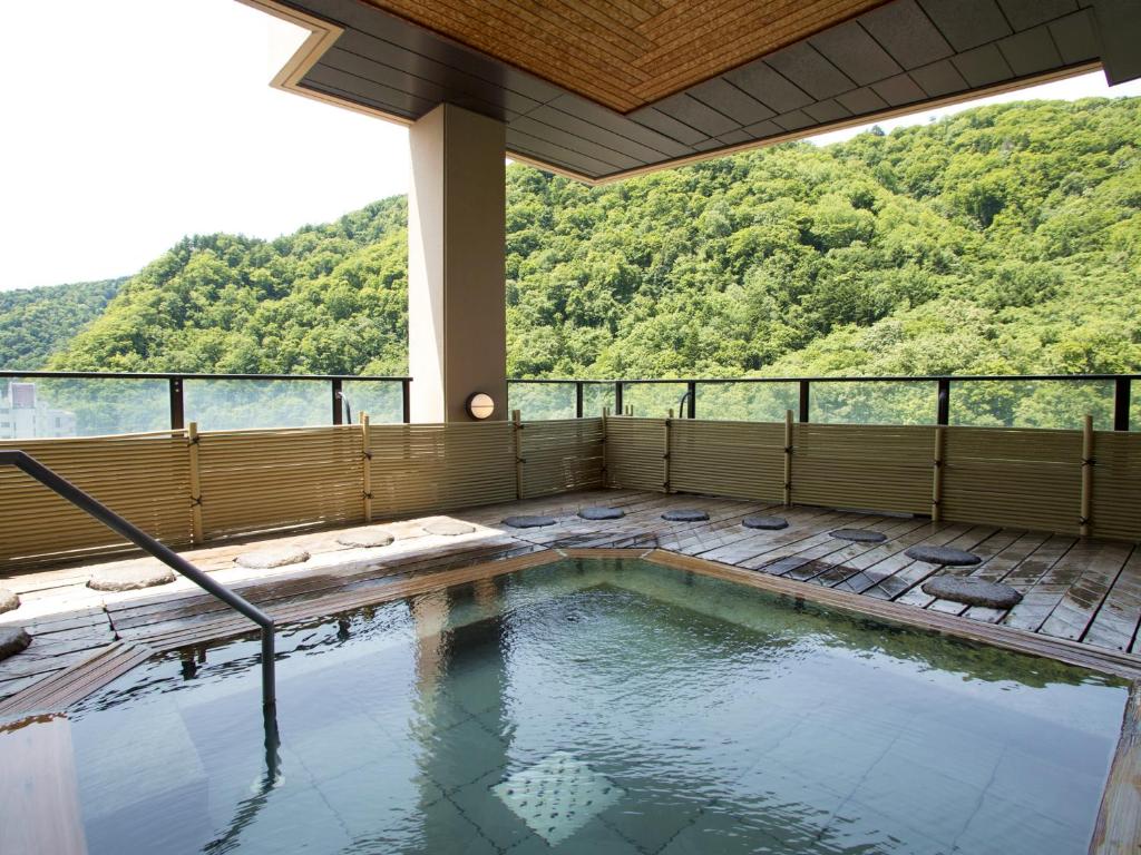 - une piscine sur la terrasse d'une maison avec vue dans l'établissement Hanamomiji, à Jozankei