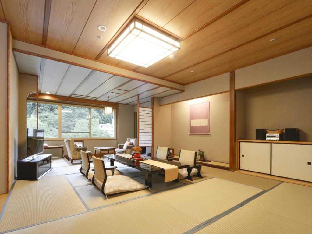 un grand salon avec une table et des chaises dans l'établissement Hanamomiji, à Jozankei