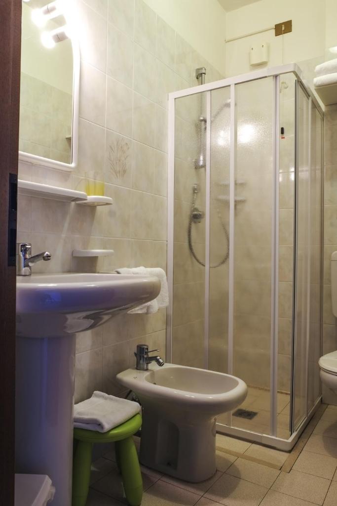 une salle de bain avec douche, lavabo et toilettes dans l'établissement Pensione Imperia, à Lignano Sabbiadoro