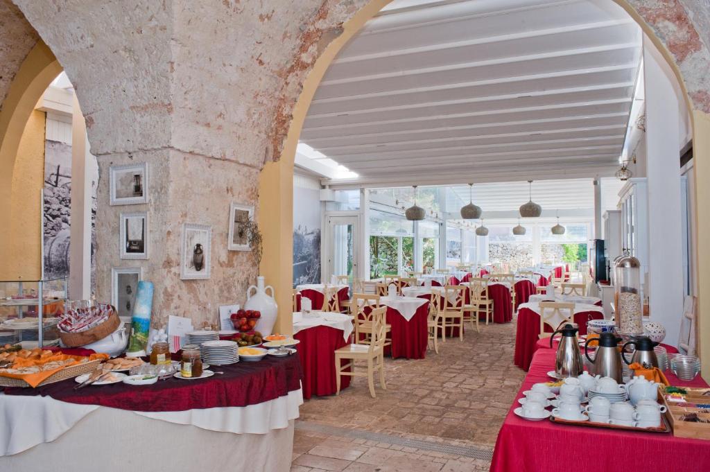 une salle à manger avec des tables et des nappes rouges dans l'établissement Antica Masseria Rottacapozza, à Torre San Giovanni