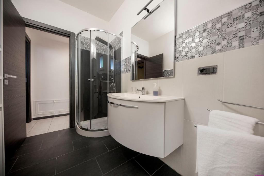 une salle de bain blanche avec une douche et un lavabo dans l'établissement Villa Francesca 30 Pax by Ville in Palermo, à Casteldaccia