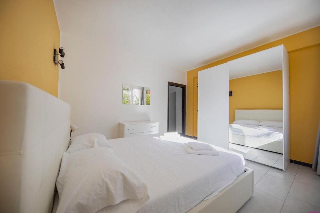 une chambre avec un lit blanc et un miroir dans l'établissement Villa Francesca 30 Pax by Ville in Palermo, à Casteldaccia