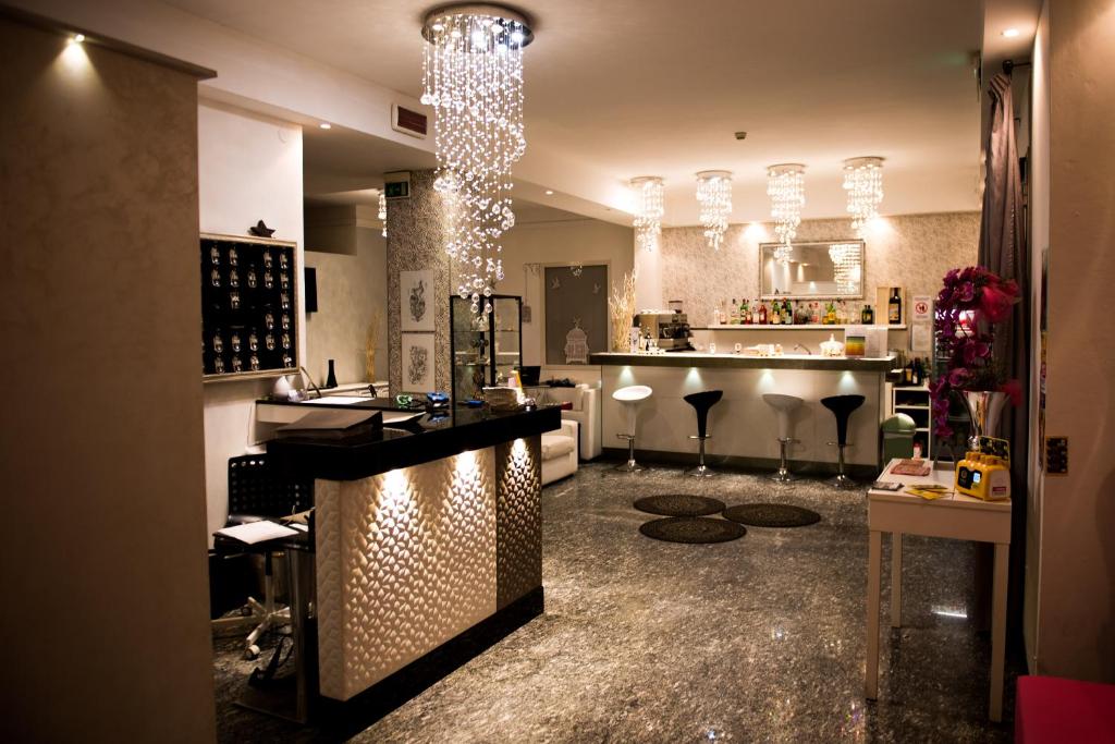 - un bar avec tabourets et un comptoir dans une pièce dans l'établissement Hotel Vela D'Oro, à Riccione