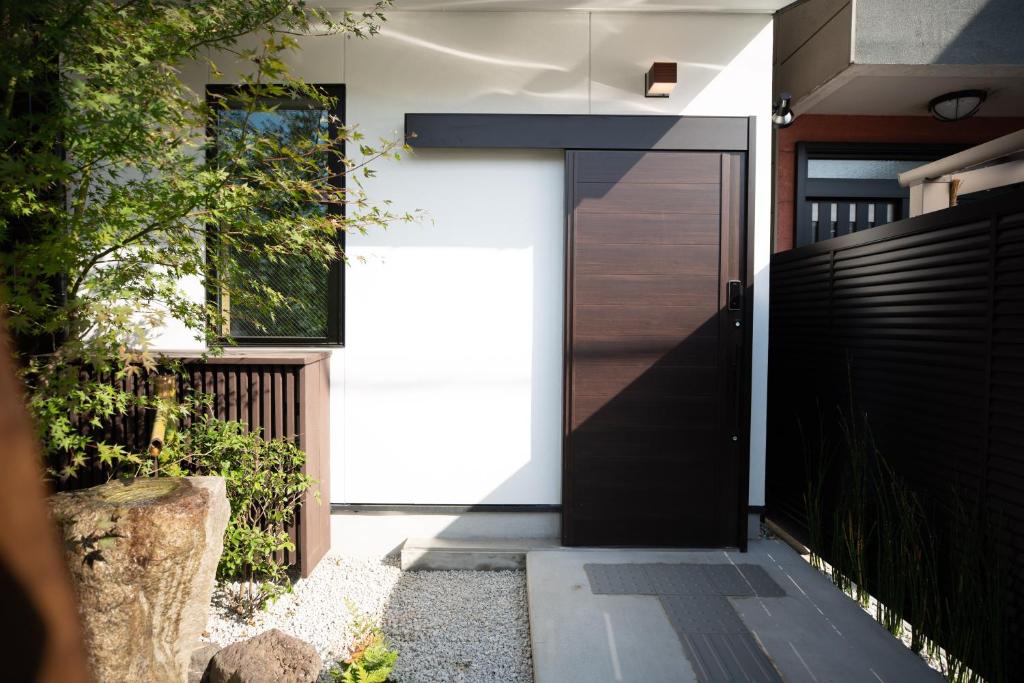 une porte noire sur le côté d'une maison dans l'établissement Onya Kaede, à Kyoto